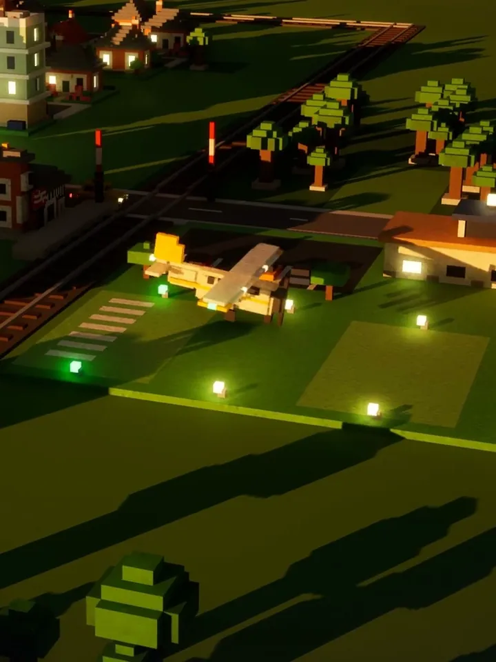 A small prop plane on a mown grass runway at dusk, its edge lamps glowing green and white, a hangar and the lit town behind.